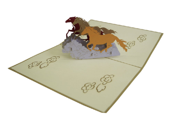 Eine Klappkarte aus Papier, die aufgeklappt ist und frei Pferde in verschiedenen brauntönen zu sehen ist.